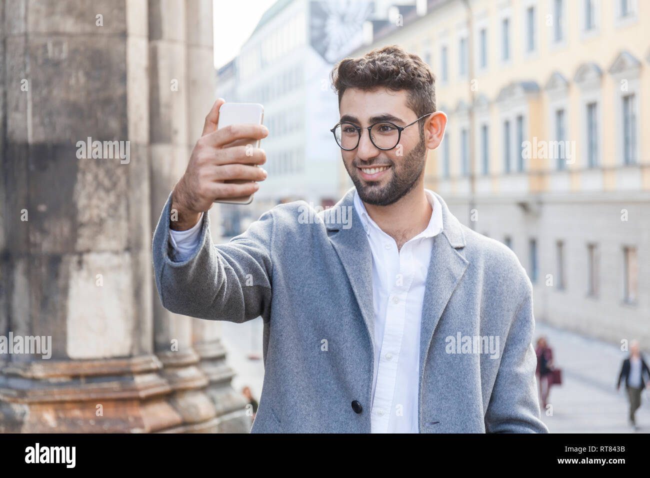 Deutschland, München, Portrait der junge Unternehmer unter selfie mit Handy in der Stadt Stockfoto