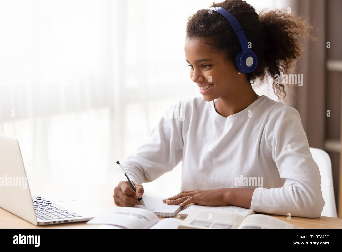 Afrikanische Schülerin e-Verwendung von Kopfhörern und Computer lernen Stockfoto