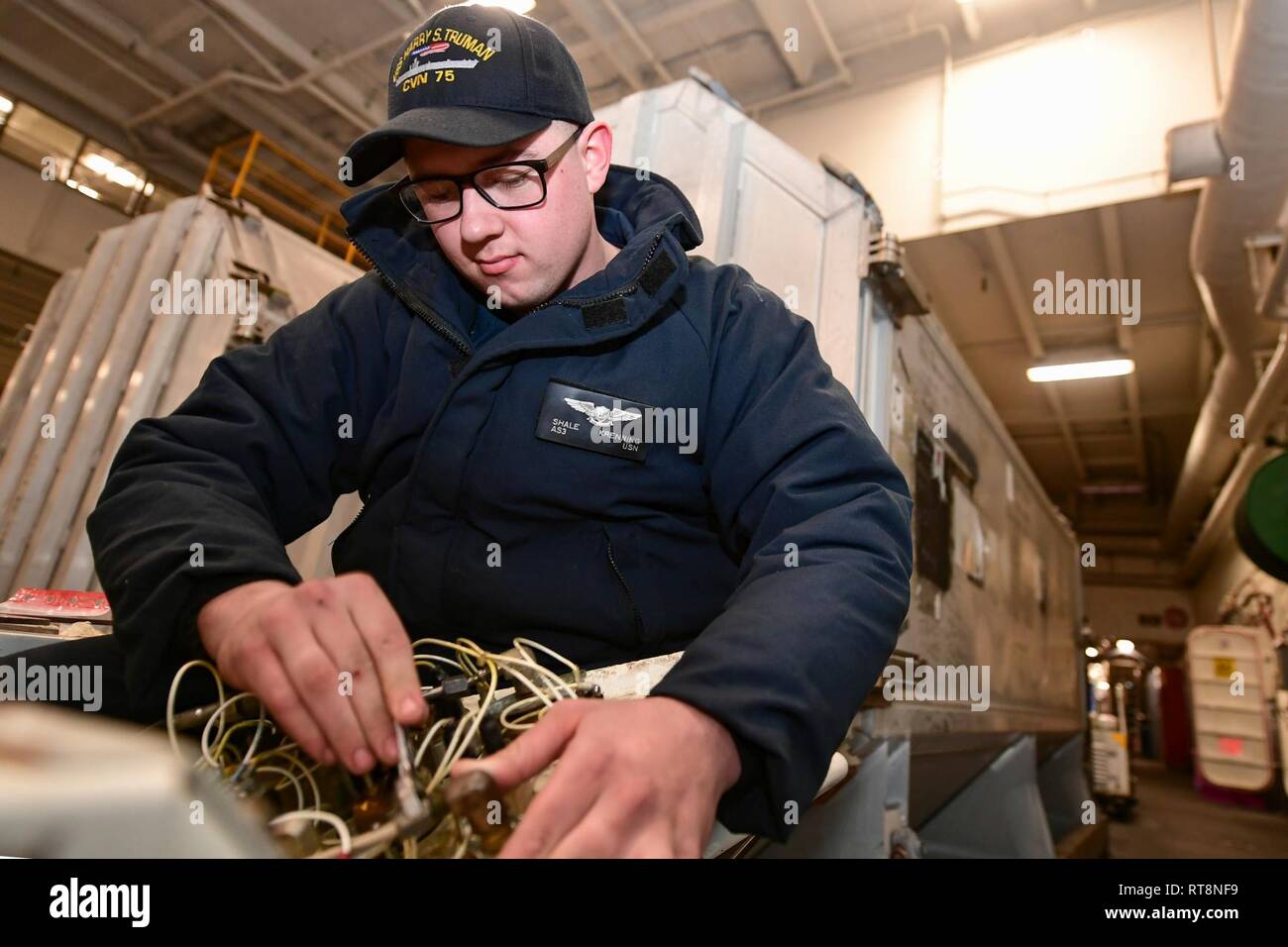NORFOLK, Virginia (Jan. 29, 2019) Aviation Support Equipment Techniker 3. Klasse Schiefer Krenning Reparaturen ein Spotting dolly im Hangar Bay an Bord der Nimitz-Klasse Flugzeugträger USS Harry S. Truman (CVN 75). Harry S. Truman ist zurzeit an der Naval Station Norfolk führen gezielte Wartung und Schulung festgemacht, und bleibt betriebsbereit. Stockfoto