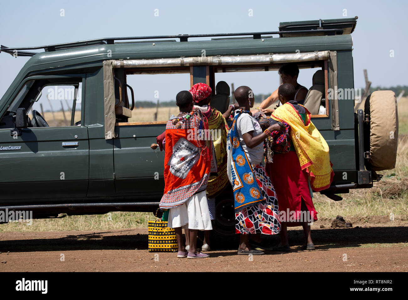 Masai Frauen in bunten Kleidern verkaufen Trinkets für Touristen, Masai Mara, Kenia Stockfoto