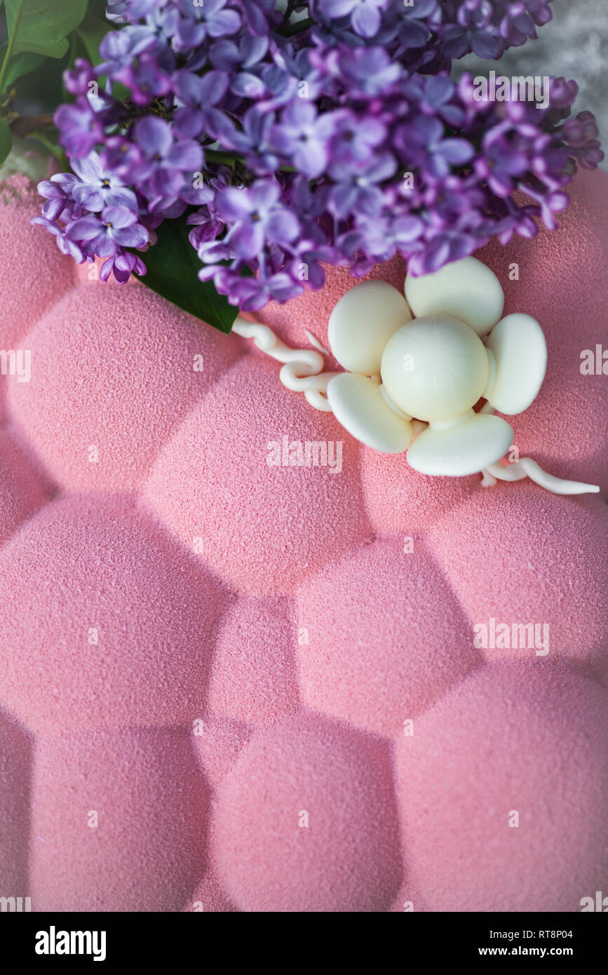 Holprige Form Kuchen mit lila Blumen Stockfoto