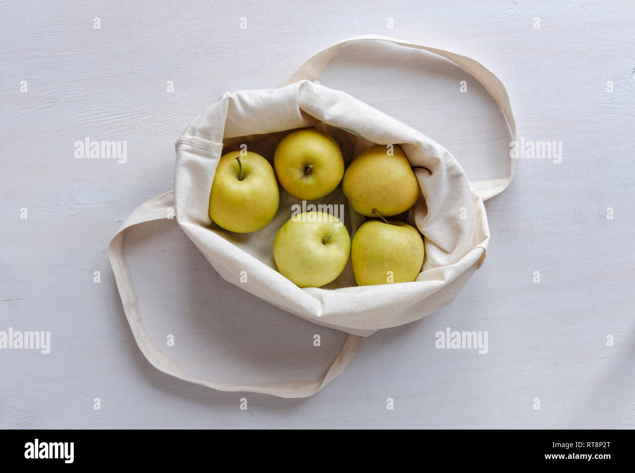 Tuch Einkaufstasche mit frischen gesunden goldenen Äpfel gefaltet öffnen die Frucht gesehen von oben nach unten von weiß in einer wiederverwendbaren Konzept zu erkennen Stockfoto