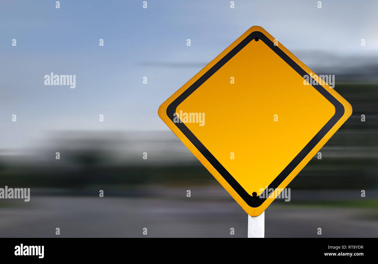 Leere gelbe Straßenwarnschild mit Kopierraum und Geschwindigkeit Unschärfe Hintergrund. Warnschild-Vorlage. Stockfoto