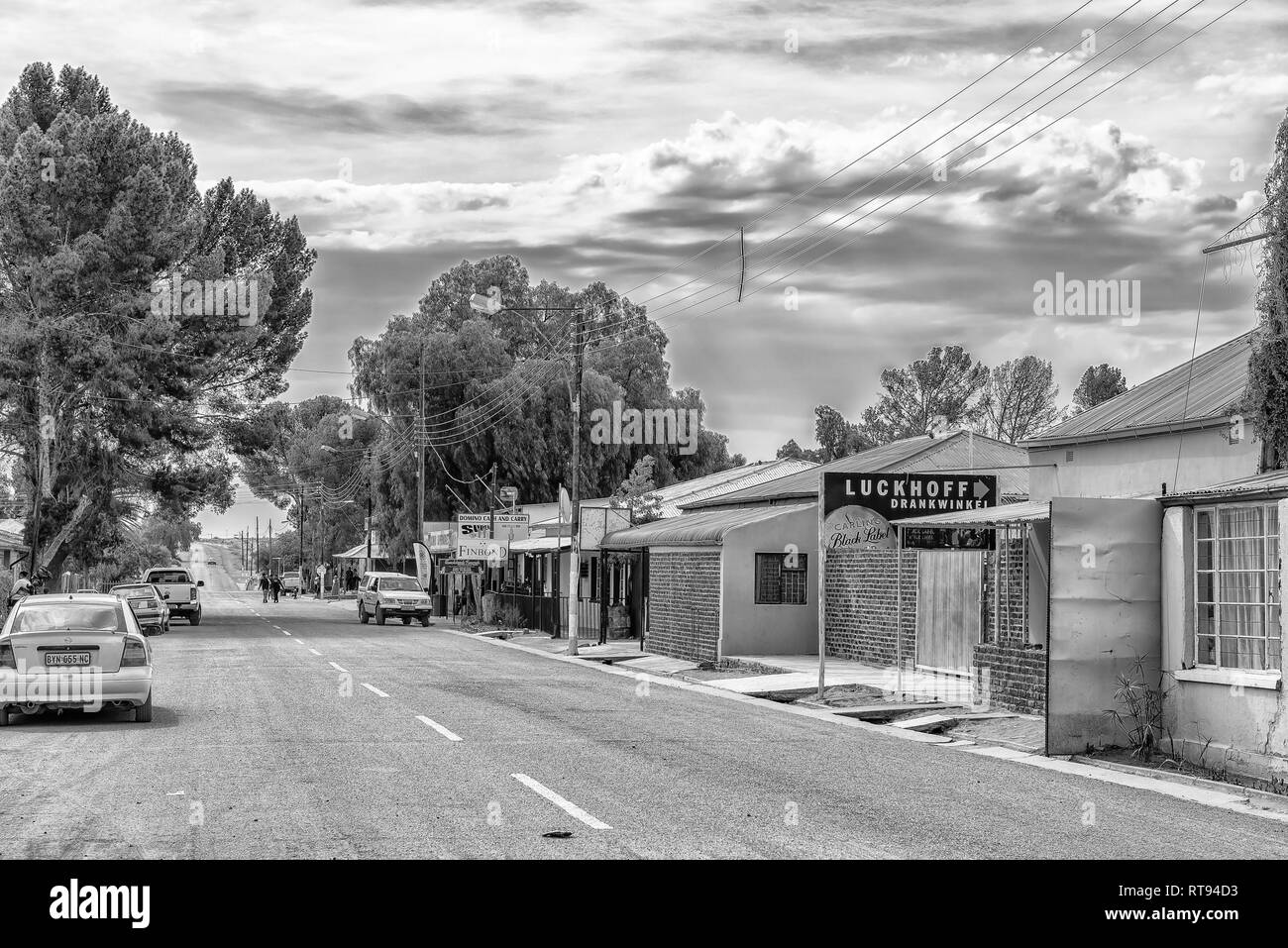 LUCKHOFF, SÜDAFRIKA, 1. SEPTEMBER 2018: eine Straße, Szene, mit Unternehmen, Fahrzeuge und Personen, die in Luckhoff in der Northern Cape Provinz. Monochrom Stockfoto