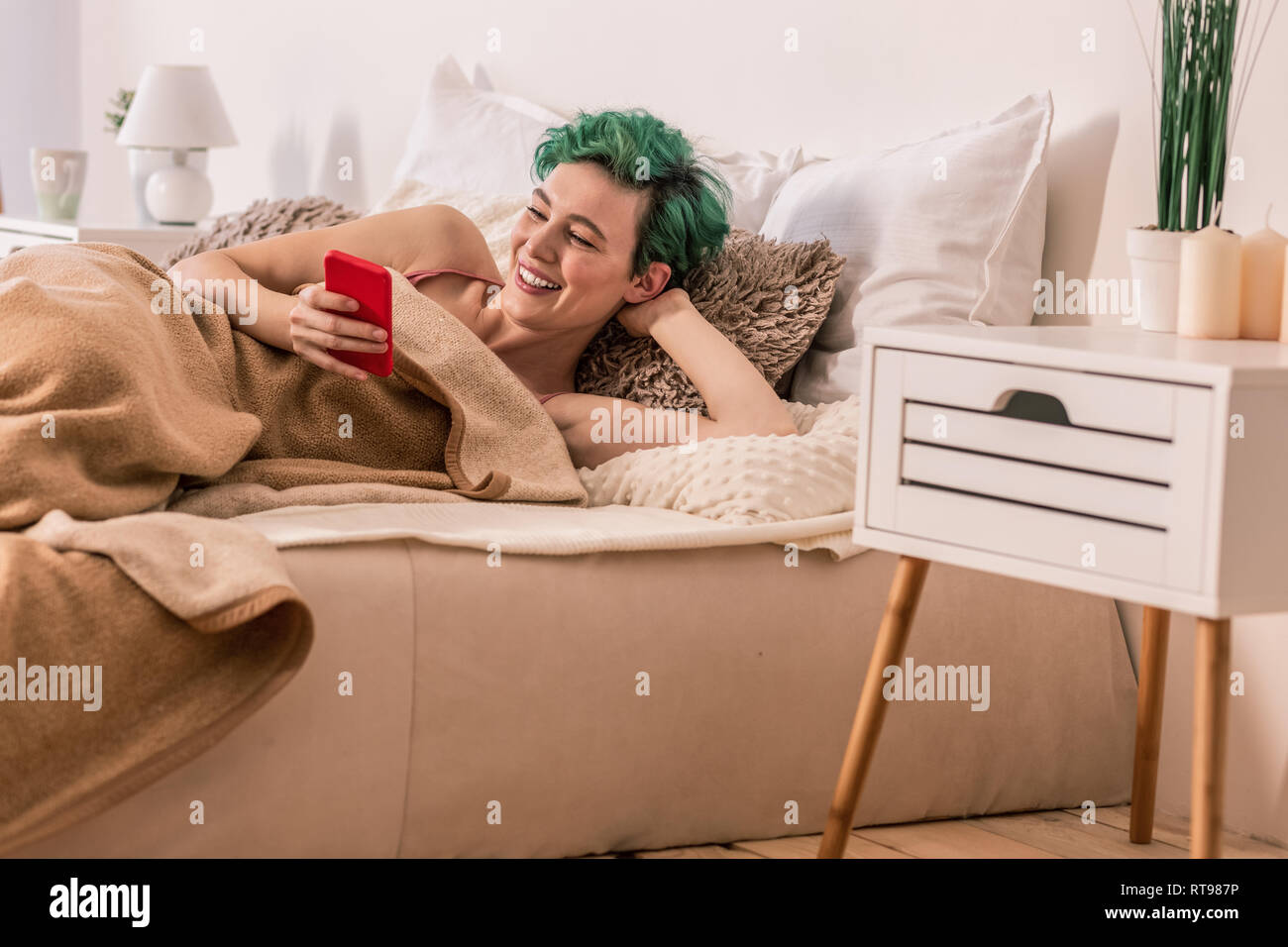 Freelancer chillen im Bett und Scrollen, social media Seite Stockfoto