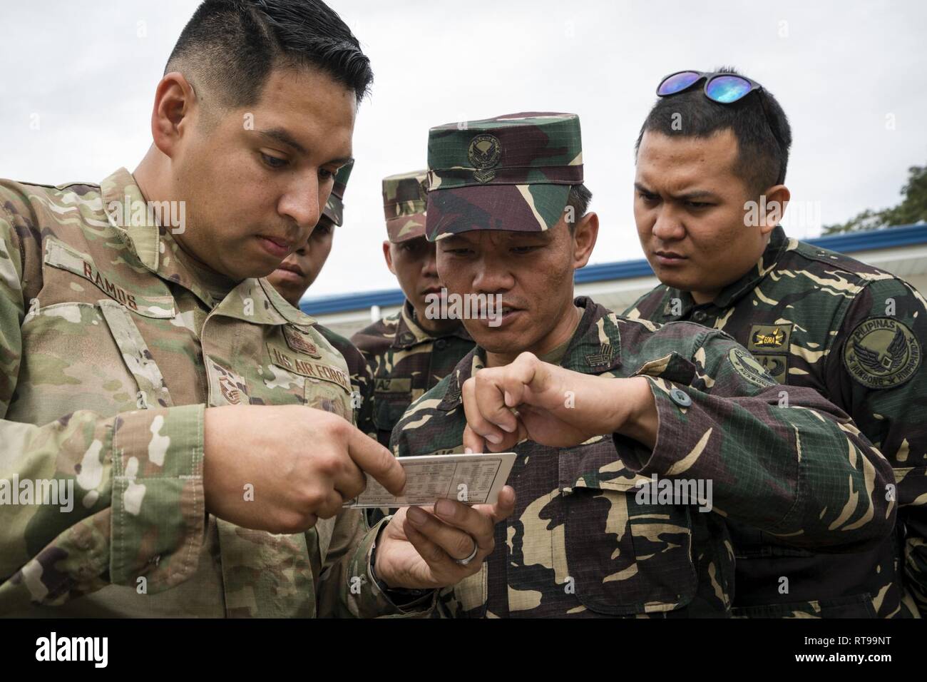 Us Air Force Master Sgt. Roger Ramos, Pacific Air Forces (PACAF) Direktion von Luft und Cyberspace Operationen Kommunikation Planer, zeigt, wie ein Werkzeug zur Kommunikation Personal von der Philippinischen Air Force 950th Kommunikations-, Elektronik- und Informationssysteme Gruppe, während ein Experte auf einem Austausch, ist Teil der bilateralen Luft bedingten Exchange-Philippines (BACE-P) im Cesar Basa Air Base, Philippinen, 30. Januar 2019 zu verwenden. Ramos bereitgestellten Anleitung zur Verwendung des Tools genau zu Sat-Terminal zu einem Satelliten umkreisen im Raum ausrichten. Dies ist Stockfoto
