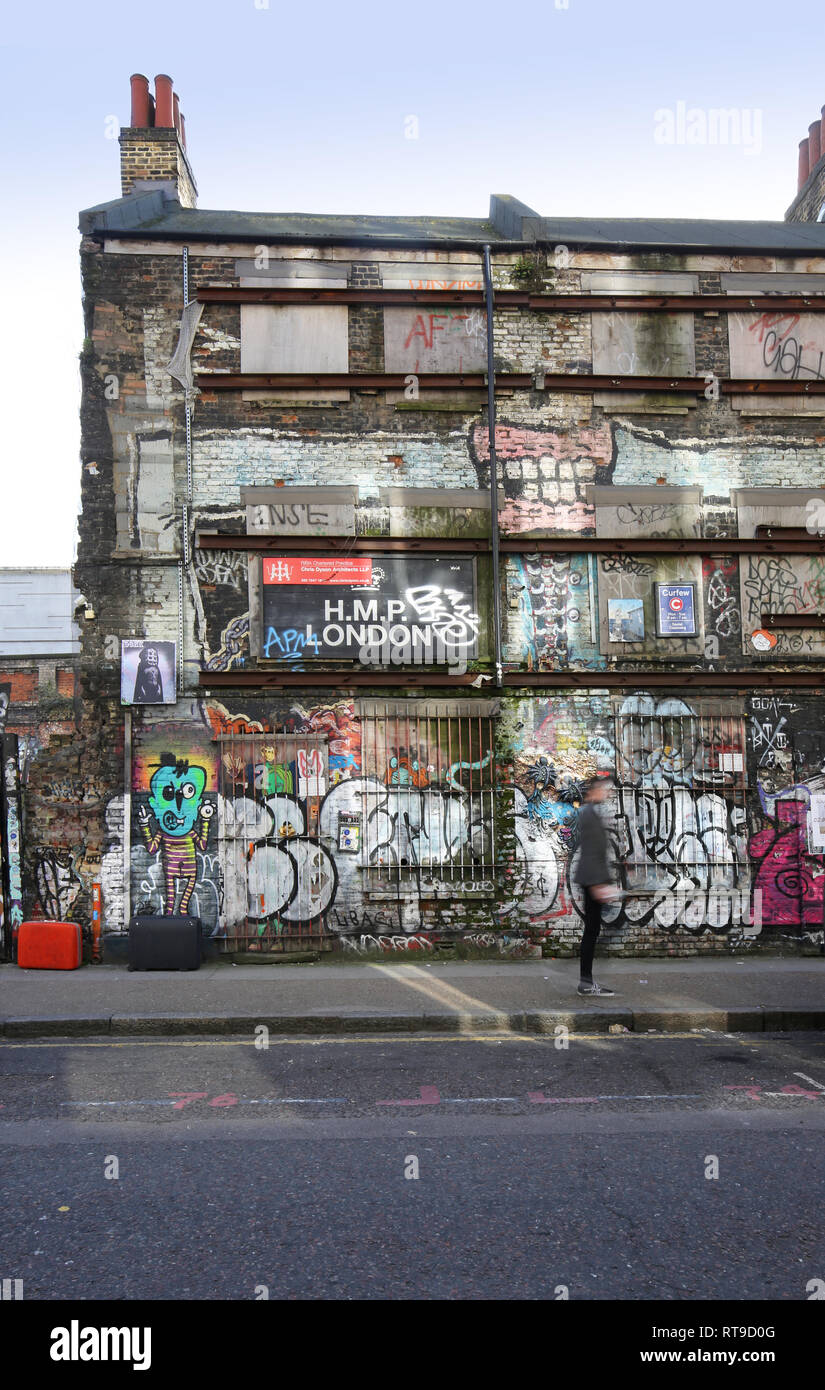 Graffiti an der Seite eines baufälligen Gebäude in der London Shoreditch, Großbritannien. Architekten Vorstand schlägt vor Sanierung Pläne in dieser mittlerweile angesagten Gegend. Stockfoto