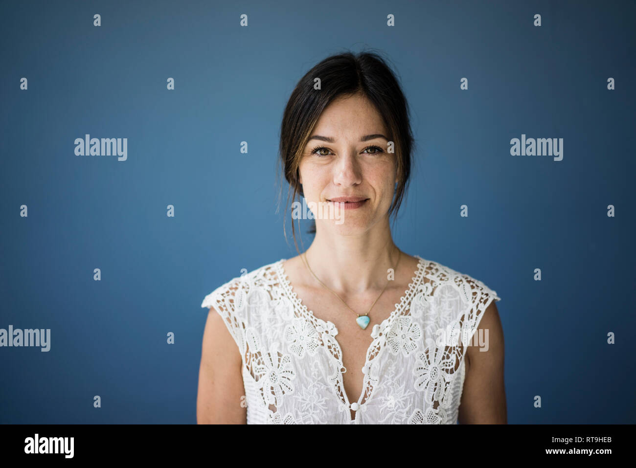 Porträt einer schönen Frau vor blauem Hintergrund Stockfoto