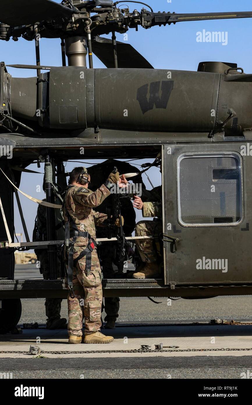 Ein U.S. Army Infanterist zur Konzernzentrale, 2.BATAILLON, 137 Infanterie Regiment, 155 gepanzerte Brigade Combat Team, Kansas Army National Guard zugeordnet, lädt eine M2010 Sniper Rifle in UH-60 Black Hawk Hubschrauber in der Vorbereitung für eine Antenne sniper Übung in der Nähe von Camp Buehring, Kuwait, Jan. 29, 2019. Die 1-108 th AHB zu U.S. Army Scharfschützen der 2-137 th Infanterie Regiment zugeordnet Aviation Support zur Verfügung gestellt. Stockfoto