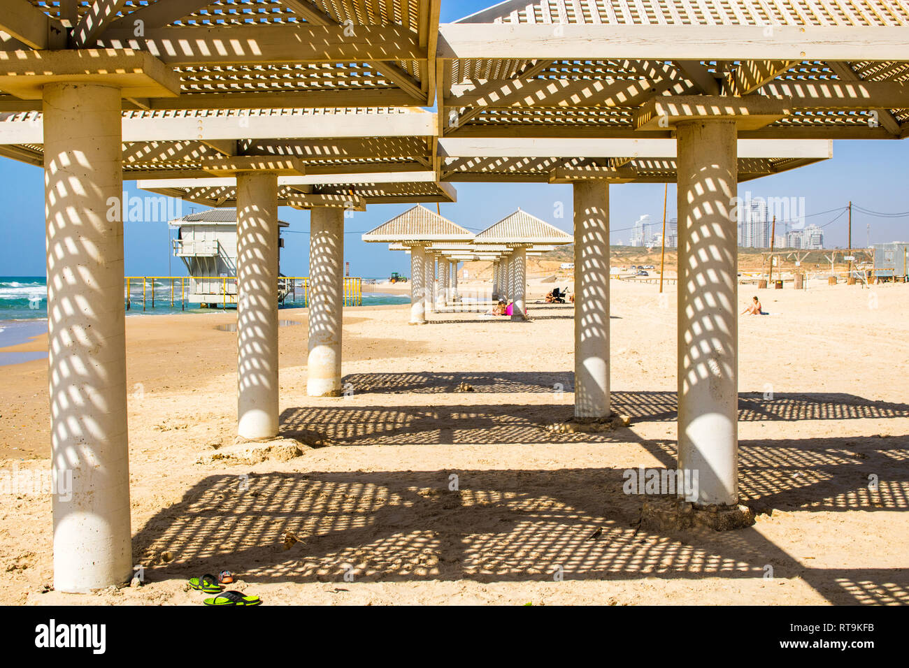 Strand von Tel Aviv, Israel. Sonniges Wetter mit strahlend blauem Himmel  und schönen Schatten form Stein Strand Sonnenschirme Stockfotografie - Alamy