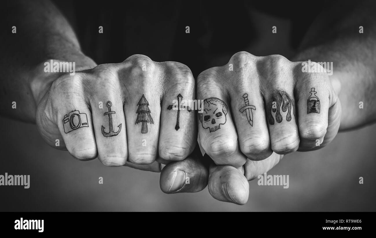 In der Nähe von Tattoos auf den Fingern und Knöcheln. Schwarze und weiße Hand tattoo Konzept Stockfoto