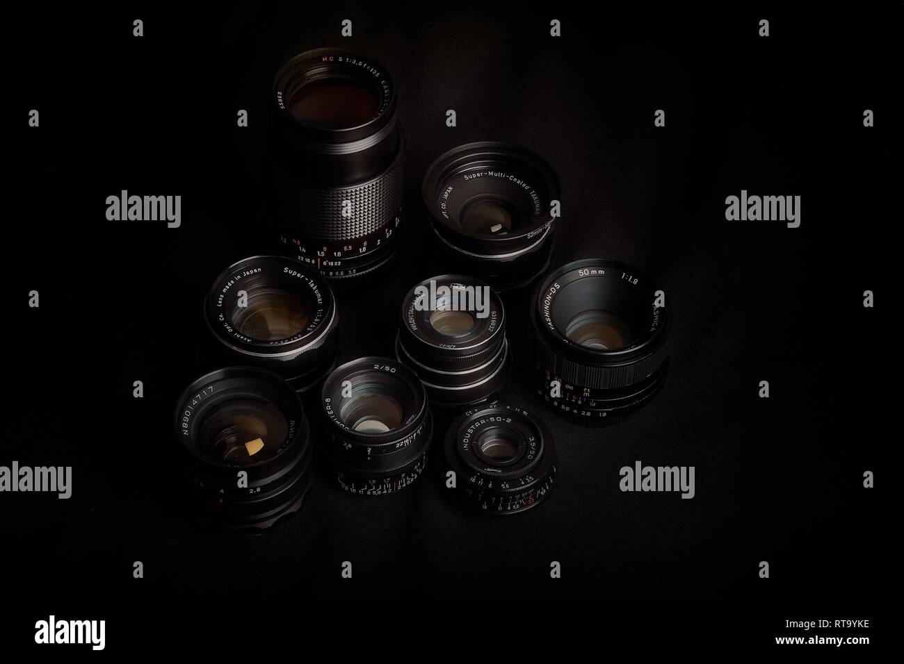 Essex, England - 28.02.2019: Sammlung von Vintage Objektive mit M42, M39 und Pentax K mounts vor einem schwarzen Hintergrund. Stockfoto