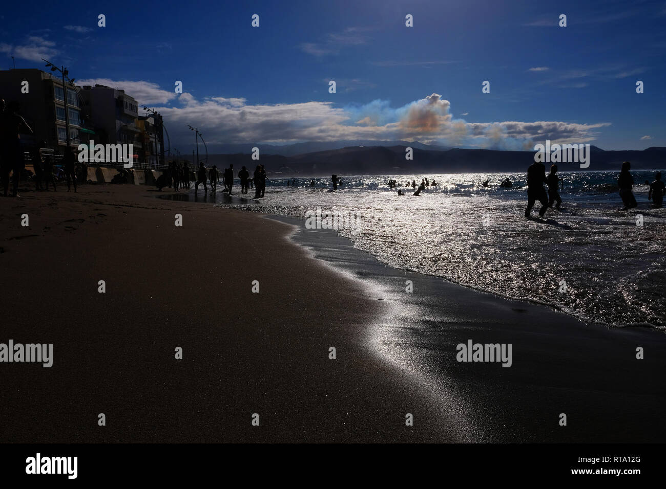 Silhouetten von Menschen genießen Sie einen sonnigen Tag am Strand Las Canteras in Las Palmas de Gran Canaria Stockfoto