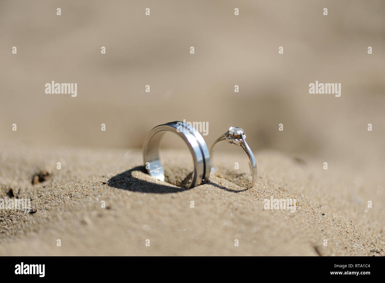 Silber Ringe mit Diamanten in Sand gesteckt Stockfoto