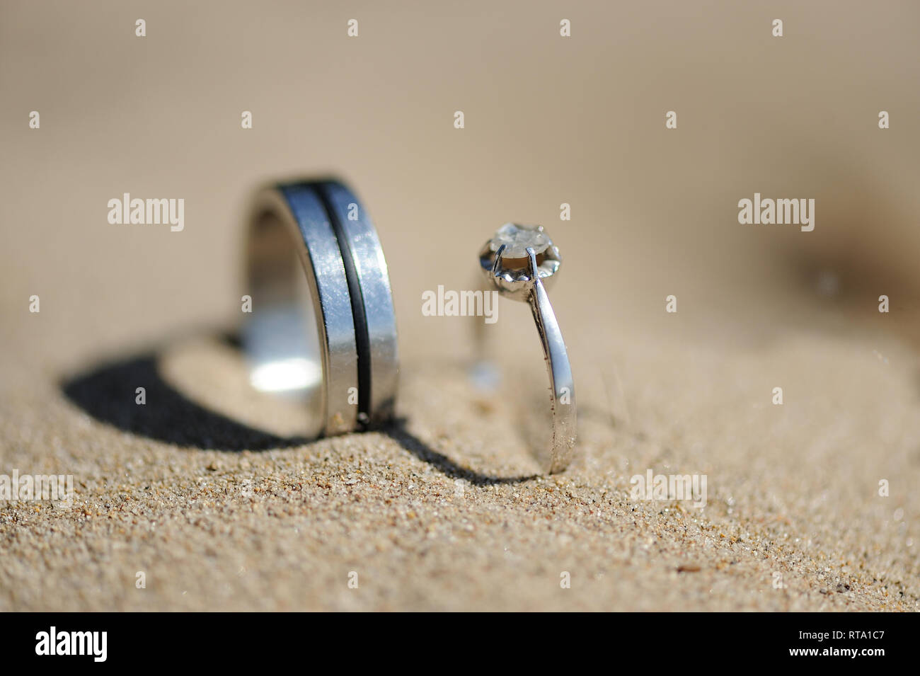 Silber Ringe mit Diamanten in Sand gesteckt Stockfoto