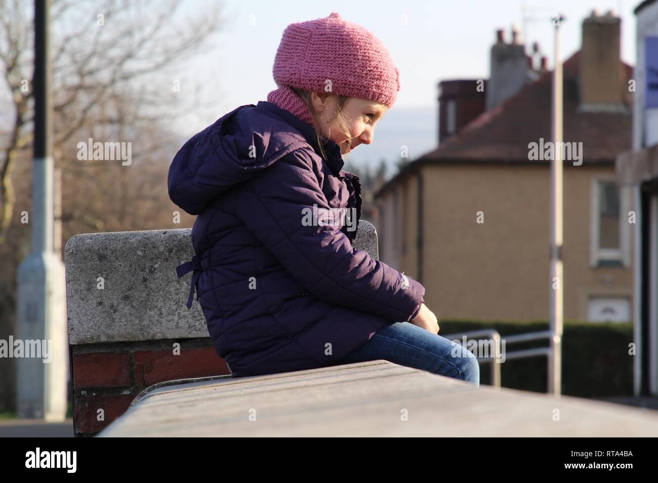 Glücklich lächelnde Kind sitzen in der Sonne Stockfoto