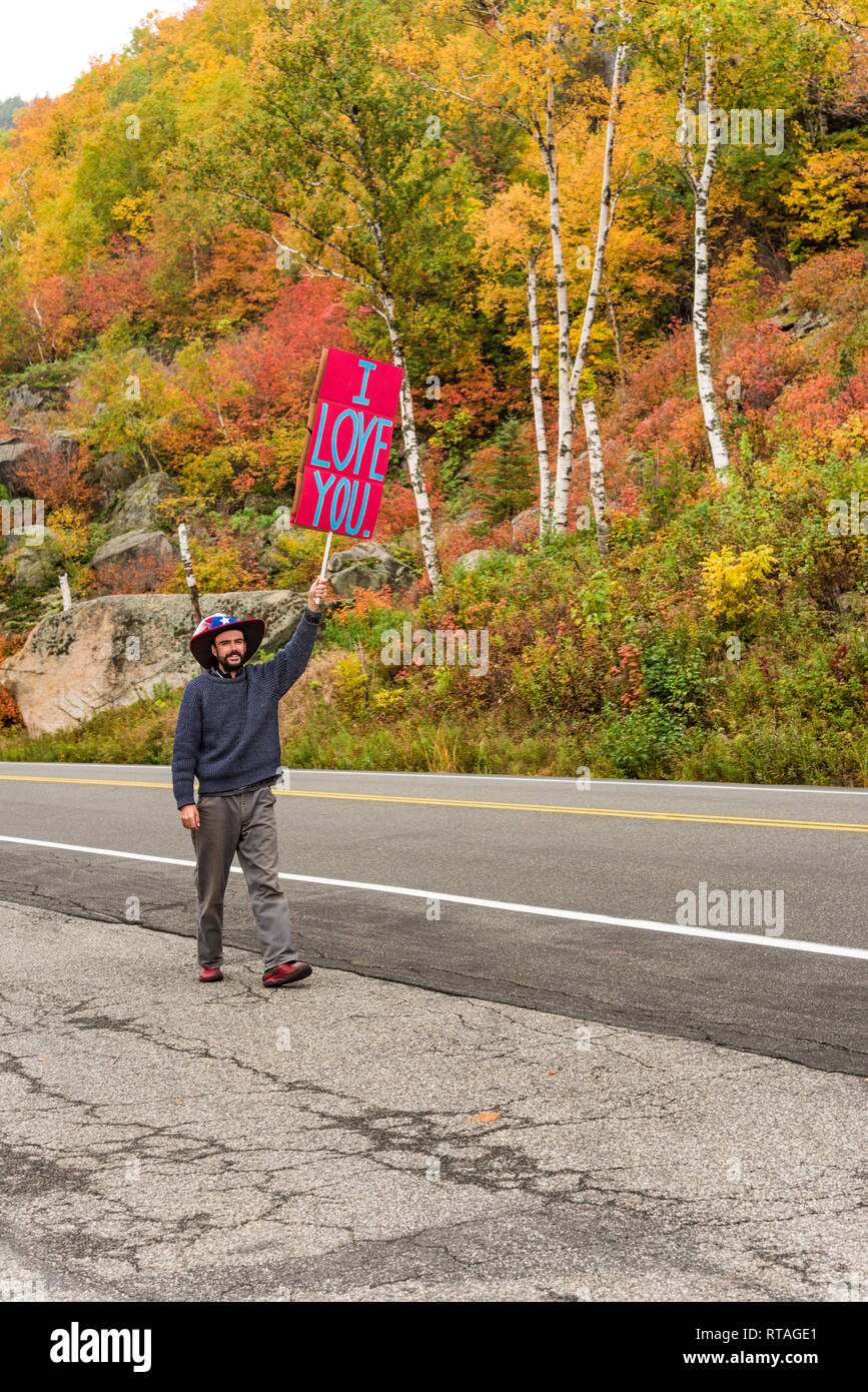 Junge Herr Verbreitung Goodwill mit 'Ich liebe dich'-Schild, Route 73, Adirondack Mountains, Essex Co., New York Stockfoto