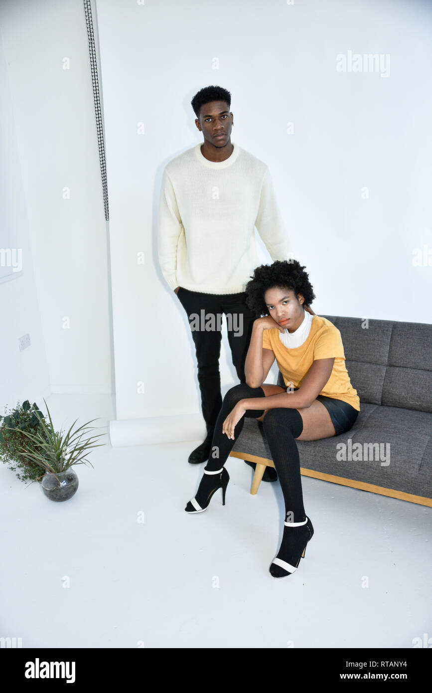 Eine junge attraktive schwarze Paar schwere in einer einfachen weißen Zimmer, moderne modische Fotoshooting. Stockfoto