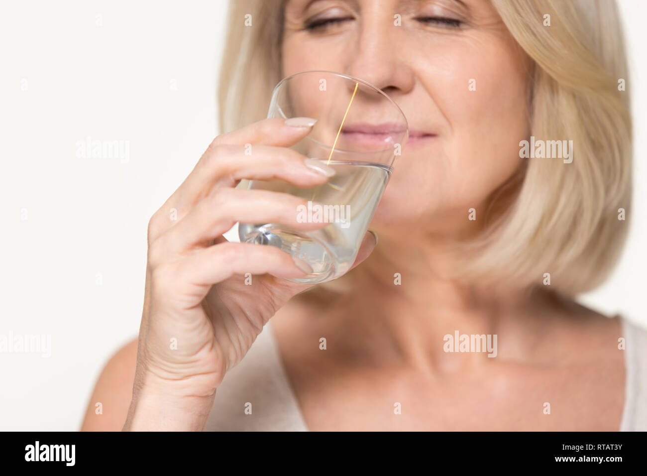 Gesund Durst senior alte Frau Trinkwasser auf Hintergrund isoliert Stockfoto