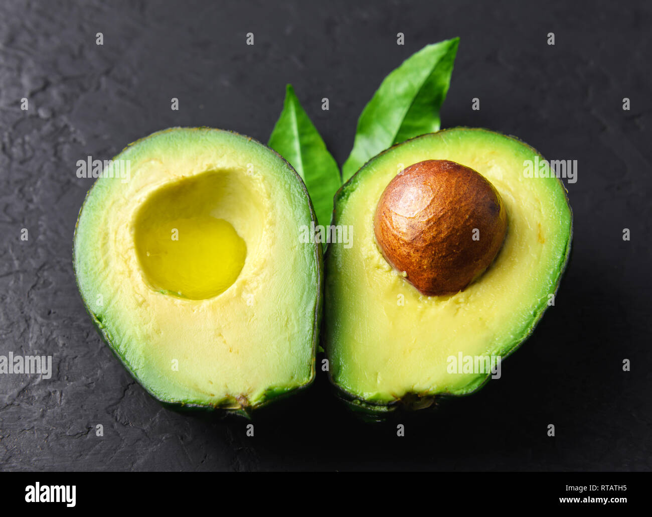 Frische avocado Obst auf einem schwarzen Brett im Landhausstil. Das Konzept der gesunden Ernährung. Essen Fotografie Stockfoto