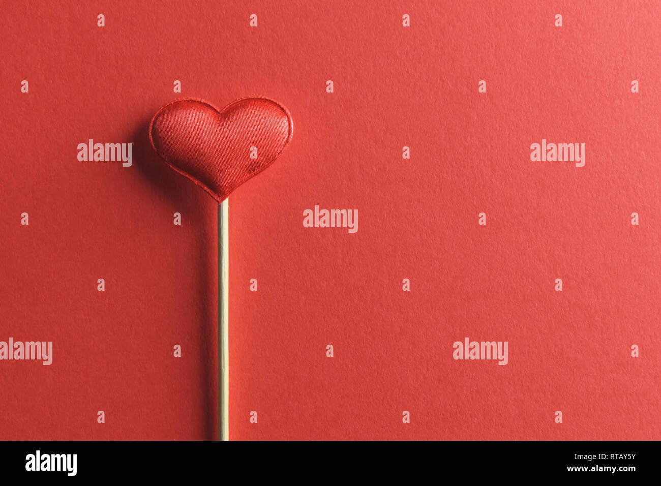 Red textile Herz auf Holzstab Nahaufnahme. Valentines Tag Hintergrund, kreative Textur und liebe Konzept Stockfoto