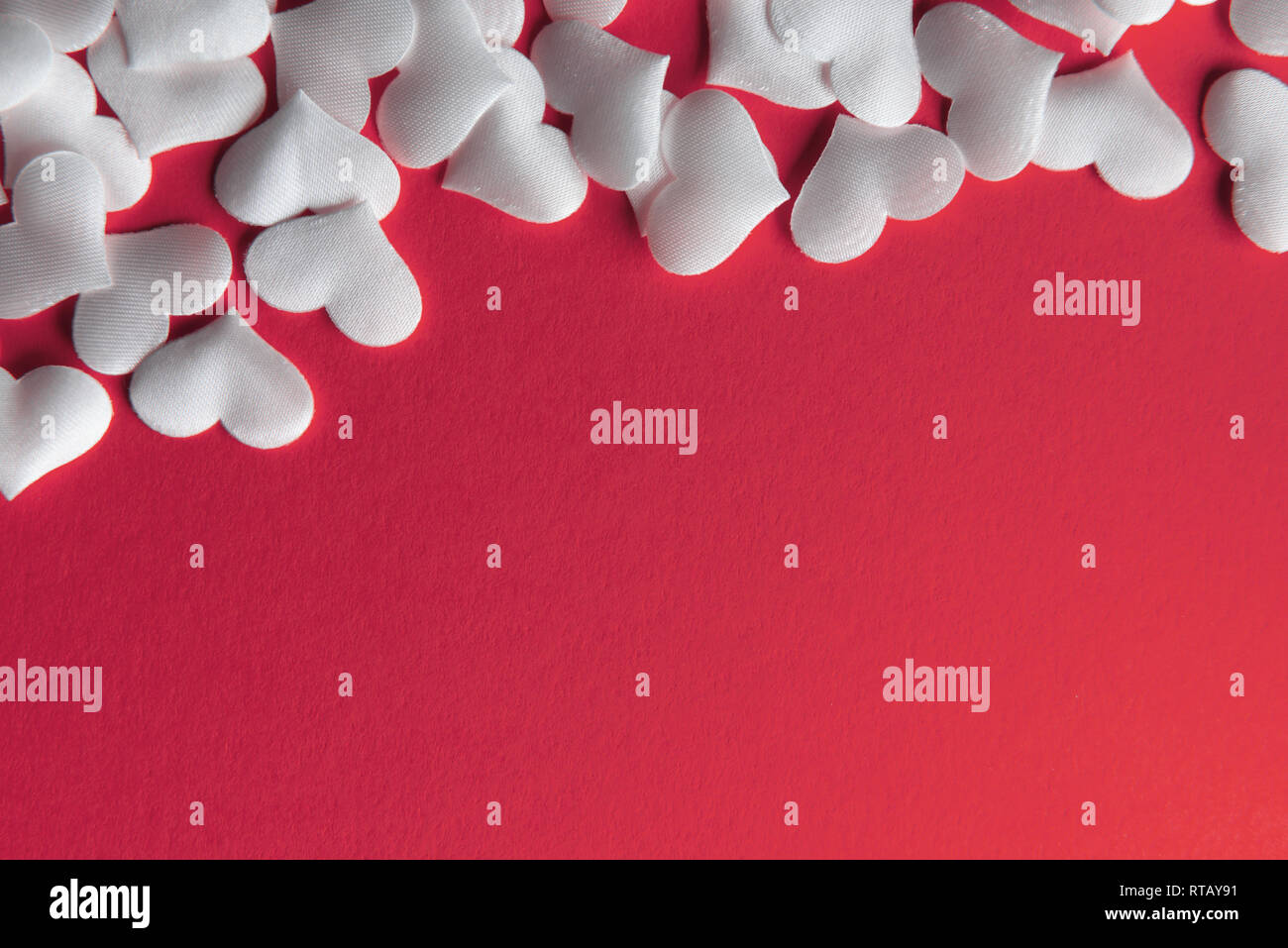 Weiß textil Herzen auf rotem Hintergrund Nahaufnahme. Valentines Tag, creative Textur und liebe Konzept Stockfoto