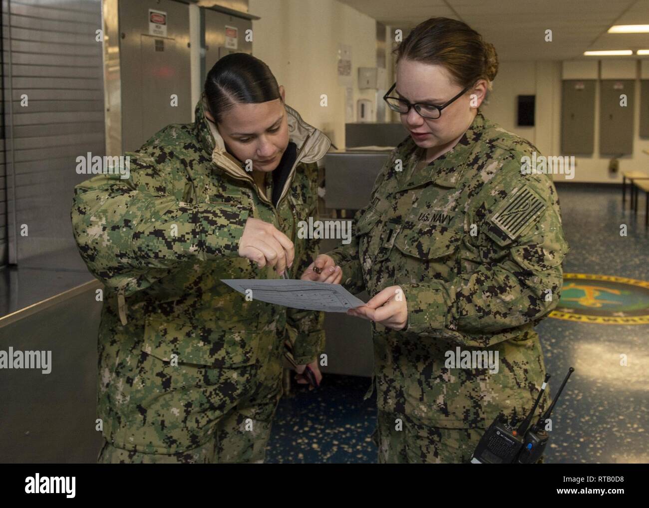 SAN DIEGO (Feb. 5, 2019) Quartermaster 1. Klasse Joshayra Verafeliciano, links, von Tampa, Fla., und Lt. j.g. Sarah Platt, von Sandpoint, Idaho, sowohl der Amphibisches Schiff USS BONHOMME RICHARD (LHD 6), überprüfen Sie die Regeln der Probefahrt auf das Chaos decks Der barge zum Schiff zugewiesen. Unteroffiziere die Prüfung machen, die gute Kenntnisse in Navigation regeln wie korrekte Schiff manövrieren sowie optische und akustische Signale auf See eingesetzt zu behalten. Bonhomme Richard ist in seinen Heimathafen San Diego. Stockfoto