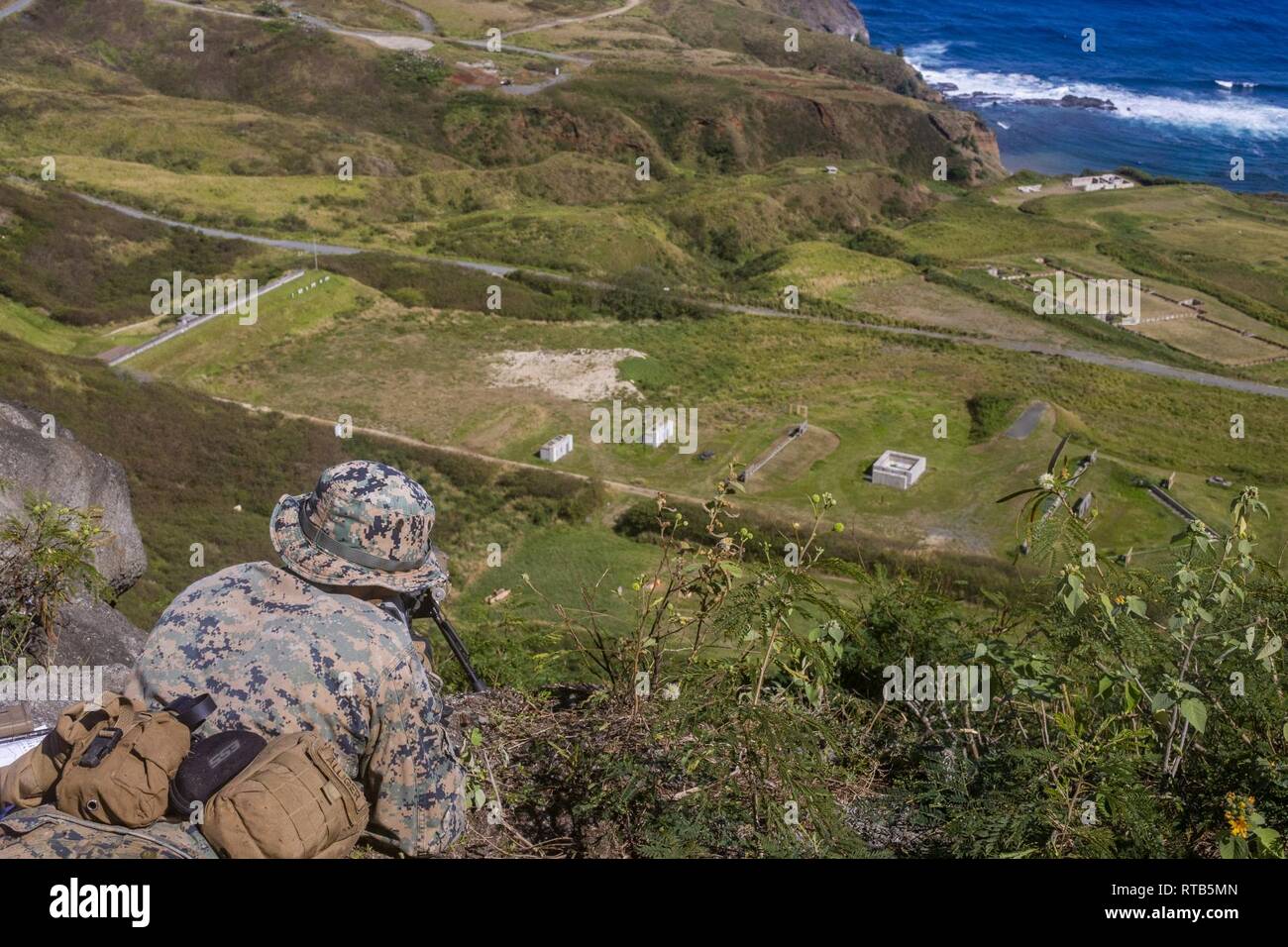 Ein US-Marine mit 2Nd Battalion, 3. Marine Regiment, 3rd Marine Division Brände M 28 Designated Marksman Rifle an der Strecke auf der Marine Corps Base Hawaii, Kaneohe Bay, Feb 7, 2018. Die Marines waren die Ausbildung ihrer Fähigkeiten in großer Höhe schießen zu erhöhen. Stockfoto