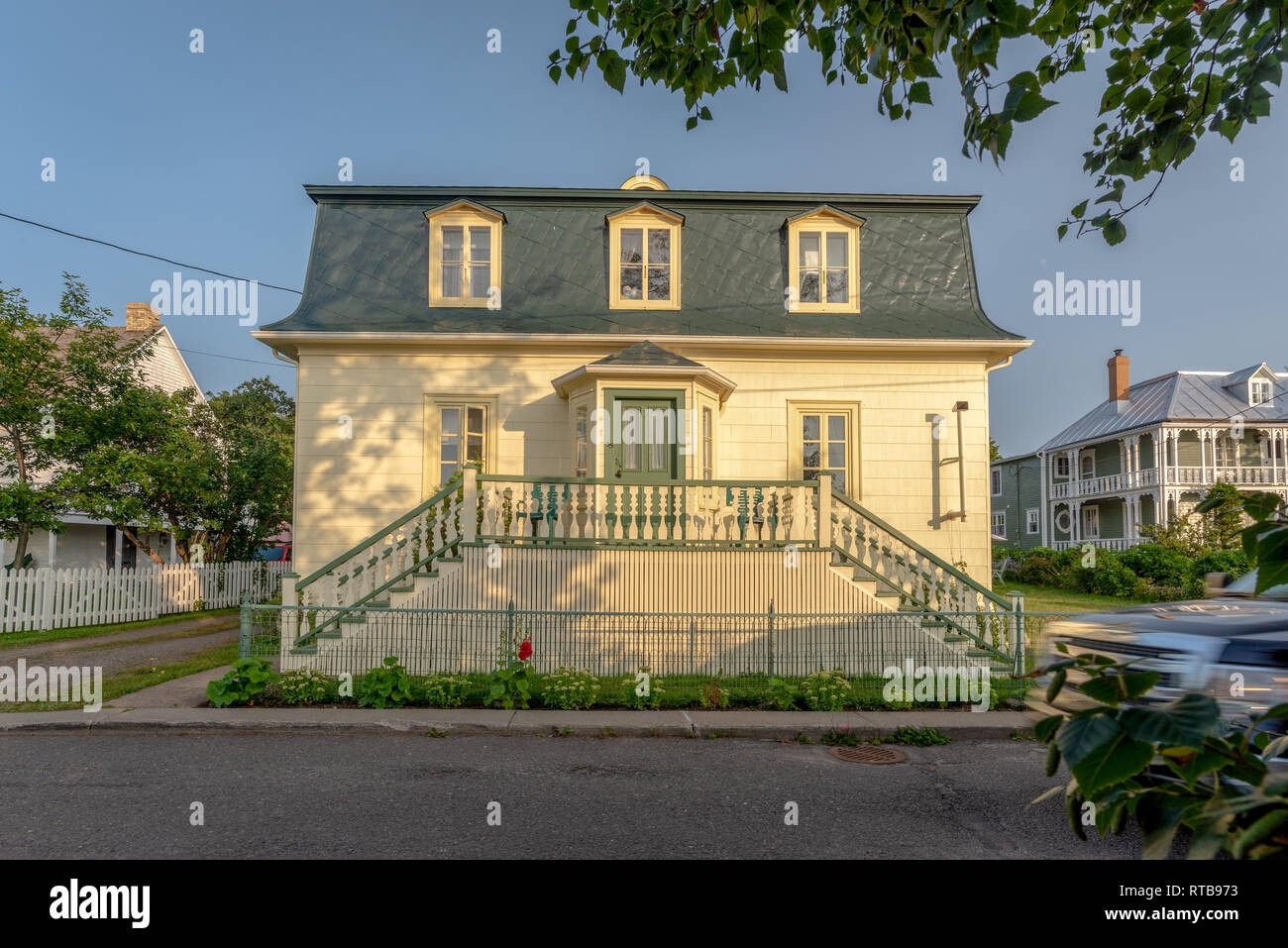 Traditionelles Haus bei Sonnenuntergang mit goldenen Ende des Tages Farben in Kamouraska, Quebec, Kanada Stockfoto