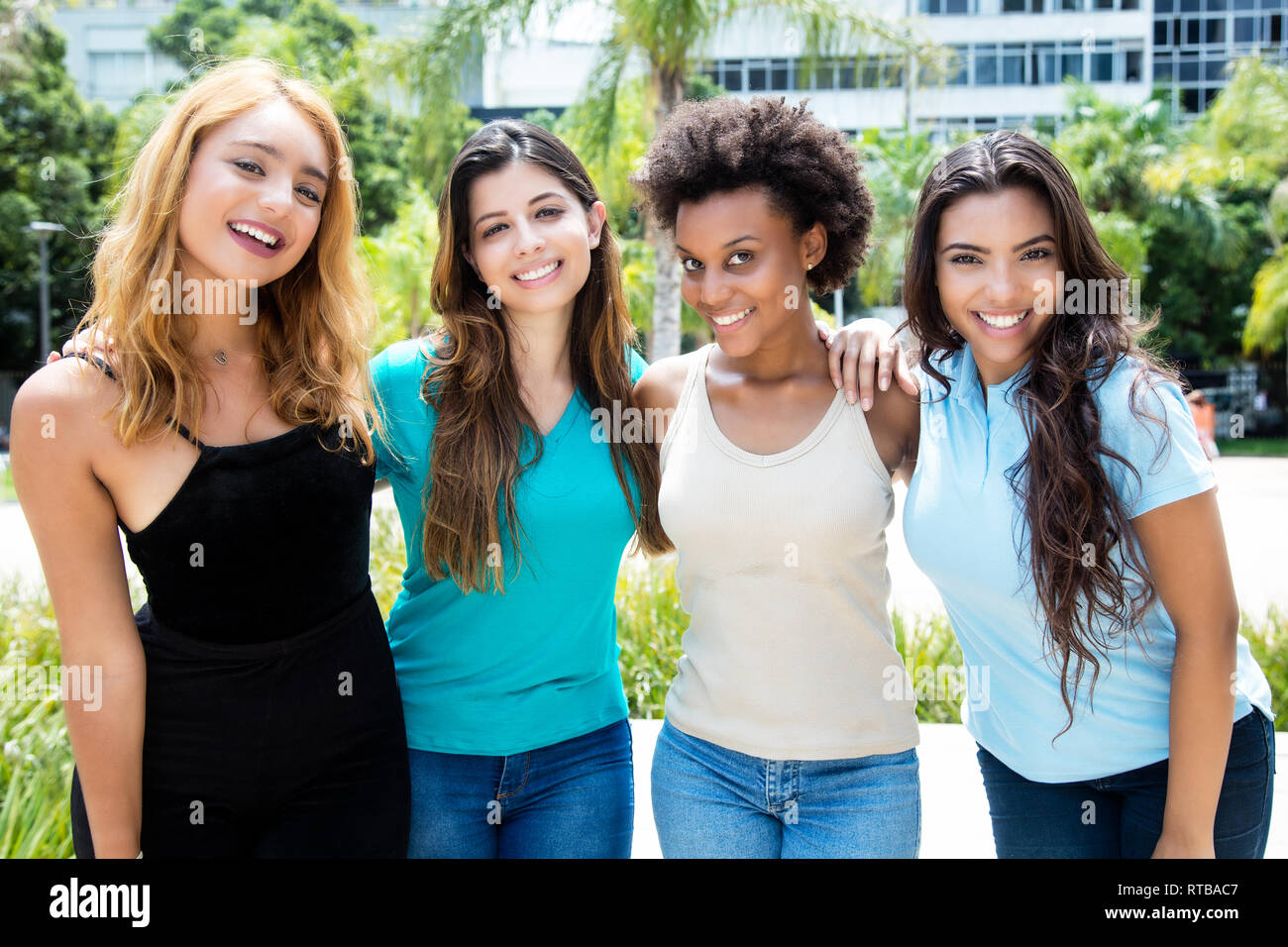 Gruppe von vier internationalen lachenden Jungen erwachsenen Frauen im Freien im Sommer Stockfoto