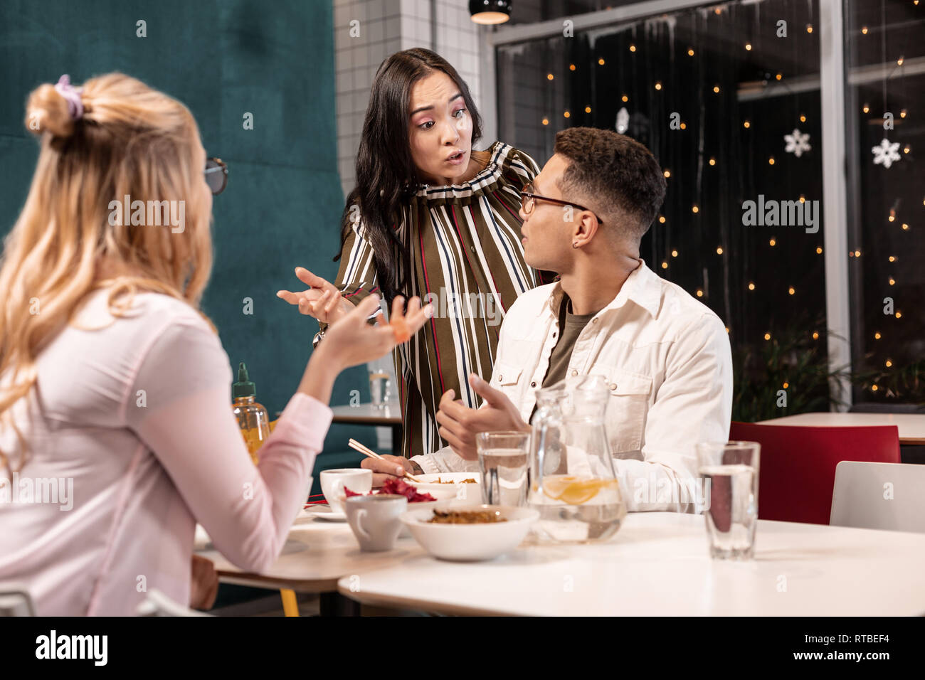 Junge Frau, die von ihrem Freund beleidigt, weil er Sie zum Abendessen mit ihrem Freund