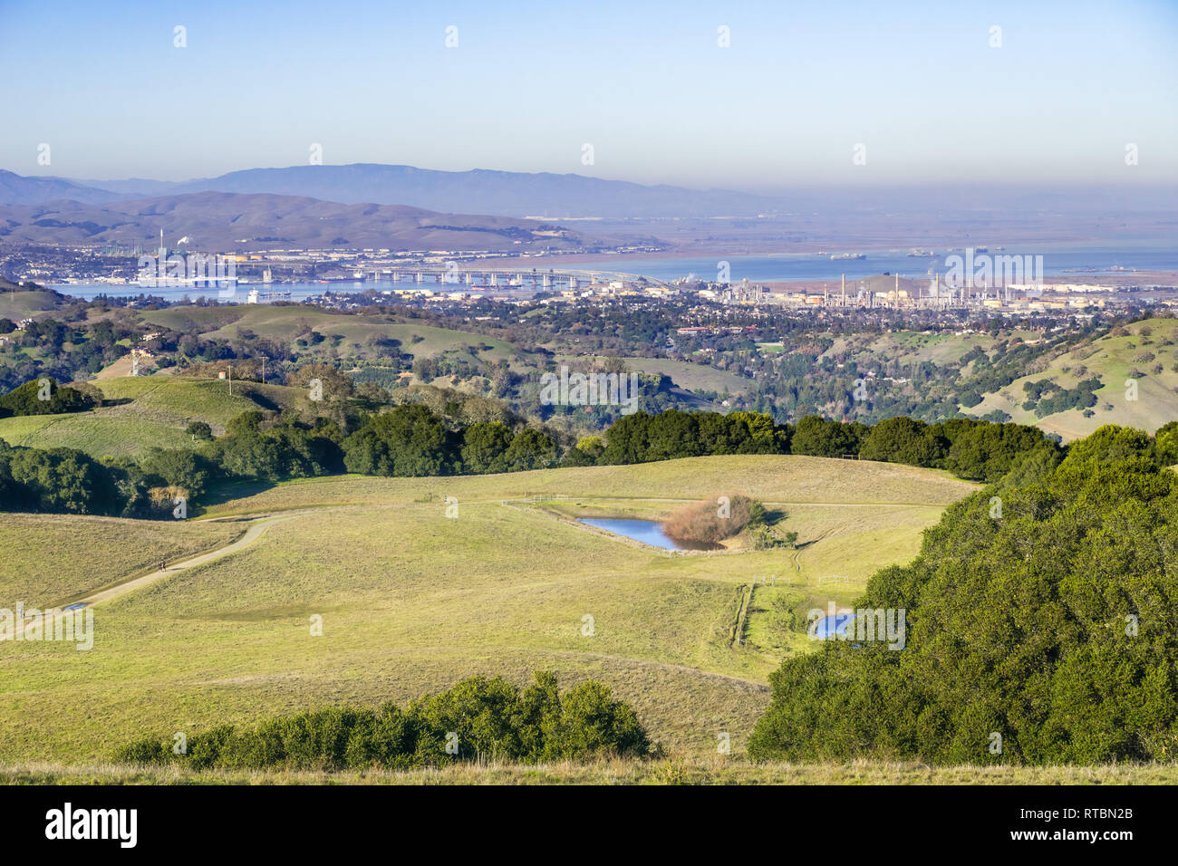Grüne Hügel in Briones Regional Park und Verschmutzung über Suisun Bay im Hintergrund, Contra Costa County, San Francisco East Bay, Kalifornien Stockfoto
