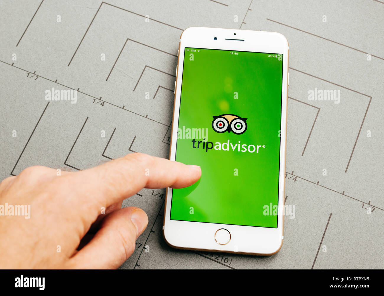 PARIS, Frankreich, 26.September 2016: Männliche hand mit neuen Apple iPhone 7 Plus nach dem Auspacken und testen, indem Sie die App Application Software online Hotel Buchung Trip Advisor Stockfoto