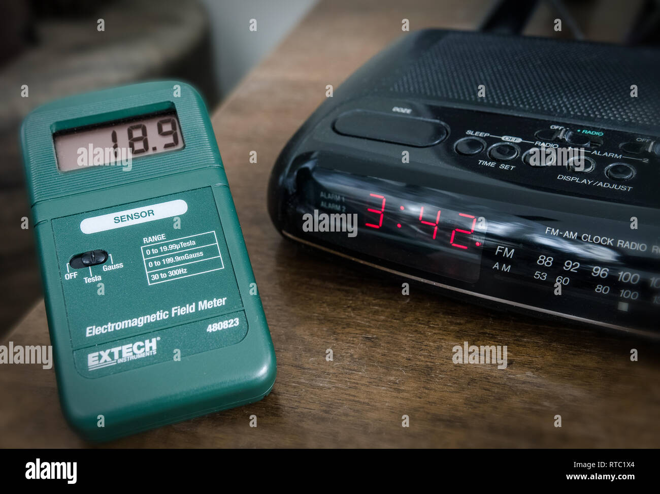 Das elektromagnetische Feldmessgerät misst wichtige Mengen von Emissionen, Gauß-Einheiten, von einem Wecker. CA. Abstand: 5 cm. Stockfoto