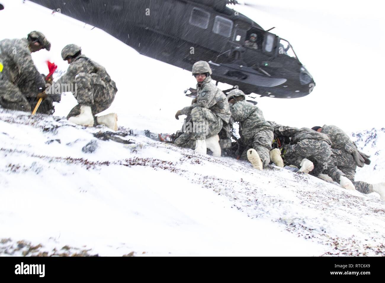 Wachposten mit dem 207 Ingenieur Utilities Distanz, mit UH-60 Black Hawk Helikopter Transport Unterstützung von 1 Bataillon, 207 Aviation Regiment, in arktischen Skills Training in Snowhawk Tal in der Nähe von Joint Base Elmendorf-Richardson, Alaska, Feb 9, 2019 teilnehmen. Aufgaben bei kaltem Wetter Ausbildung, Langlaufen, Schneeschuhwandern, Lawinenkunde und anderen Arctic warfare Aufgaben. Stockfoto