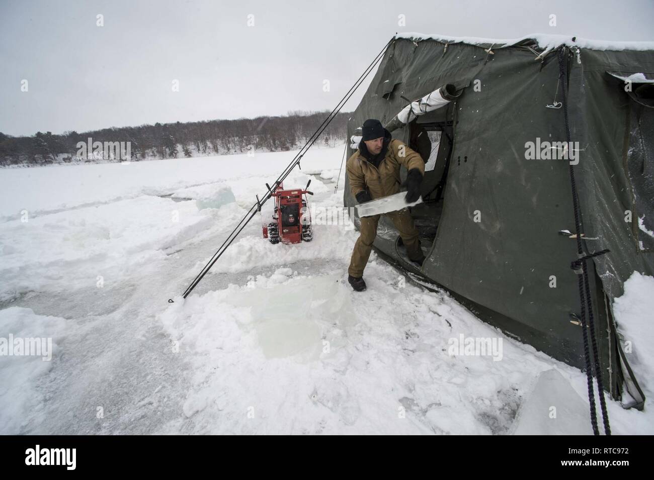 Wenig fällt, Minn (Feb. 11, 2018) Senior Chief Marine Diver Jeff Corrie, für die Beseitigung von Explosivstoffen (EOD) Gruppe (EODGRU) 2, Eis entfernt aus einem Eisloch während Eis tauchen Ausbildung auf einem zugefrorenen See in Camp Ripley in Minnesota zugeordnet. Das Training, das ist die größte unabhängige Eistauchen Betrieb von mobilen Tauchen und Bergung (MDSU) 2 auf dem neuesten Stand gehalten wird, mehr als 50 Taucher aus MDSU EODGRU 2, 2 und EOD Training und Auswerteeinheit 2 ausgebildet. Stockfoto