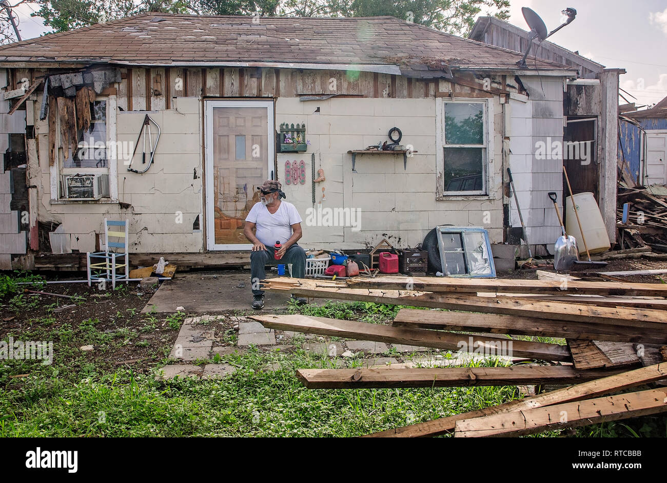 Joe Guerra sitzt vor seinem Sturm - beschädigte Haus als Er wartet auf seine Tochter nach dem Hurrikan Harvey, der 4. Oktober 2017, in Refugio, Texas. Stockfoto