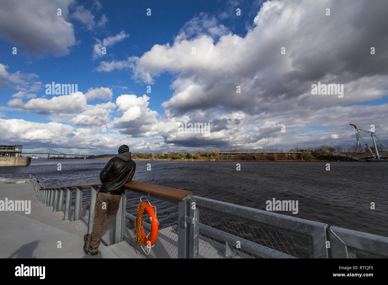 MONTREAL, KANADA - 7 November, 2018: Mann beobachten Saint Lawrence River in Montreal, Quebec. Pont Jacques Cartier Brücke ist sichtbar in backgro Stockfoto