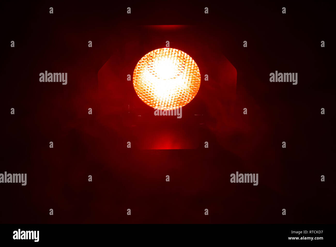 Rotes Licht mit Rauch auf dunklem Hintergrund. Ausrüstung für Photo Studio. Stockfoto