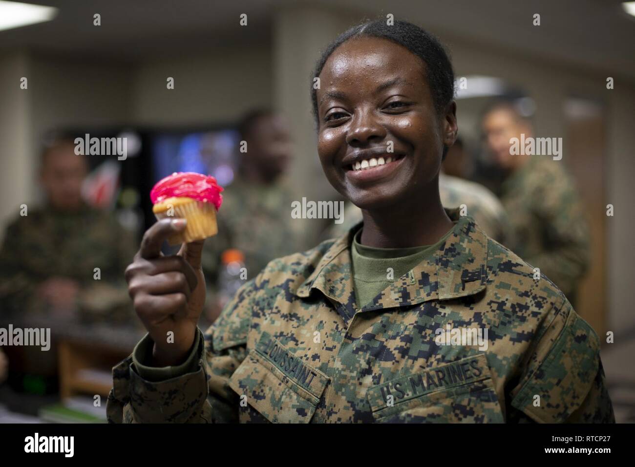 Us Marine Corps Pfc. Joanne Louissaint, ein Student zugeordnet die Personaladministration Schule, Marine Corps Combat Service Support Schulen (MCCSSS), posiert für ein Foto während der United Service Organisationen" (USO) Cupcake Drop in Camp Johnson, N.C., 14.02.2019. Die Jacksonville, N.C., USO brachte eine süße Überraschung zu MCCSSS Studenten, die von der lieben am Valentinstag durch Backen und spenden Cupcakes für den Betrieb: Cupcake fallen. Stockfoto