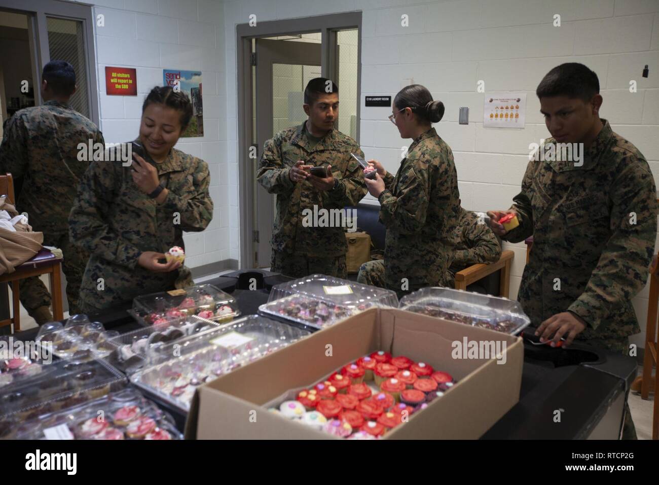 Us-Marines zu Masse Schule zugewiesen, Marine Corps Combat Service Support Schulen (MCCSSS), beteiligen sich an der United Service Organisationen" (USO) Cupcake Drop in Camp Johnson, N.C., 14.02.2019. Die Jacksonville, N.C., USO brachte eine süße Überraschung zu MCCSSS Studenten, die von der lieben am Valentinstag durch Backen und spenden Cupcakes für den Betrieb: Cupcake fallen. Stockfoto