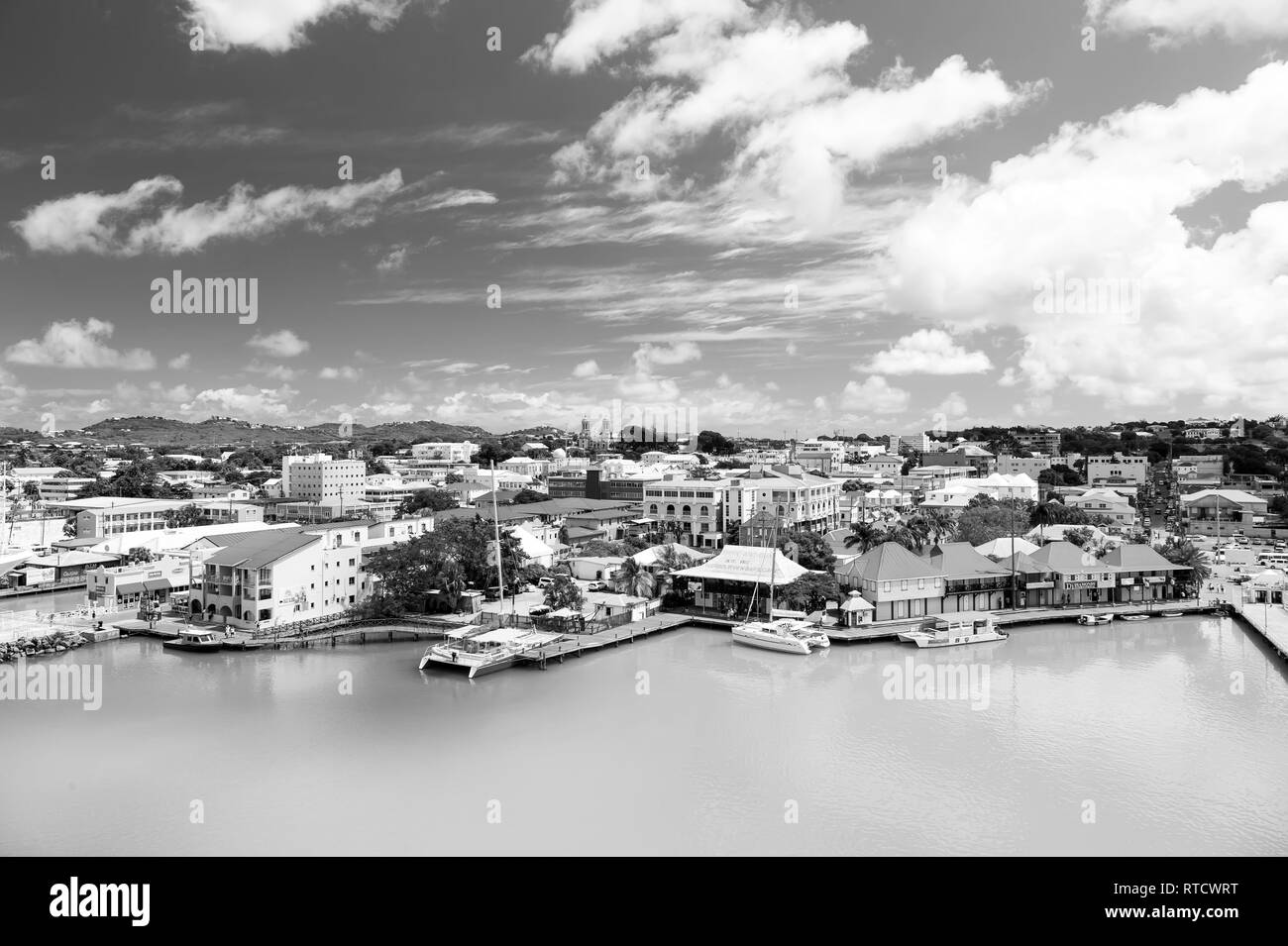 St. Johns, Antigua - März 05, 2016: Bucht mit niedlichen Häuser am Hafen mit Yacht, Boot, Schiff im Meer, Wasser, blau bewölkter Himmel sonnigen Sommer auf natürliche Hintergrund. Reisen und Urlaub Stockfoto