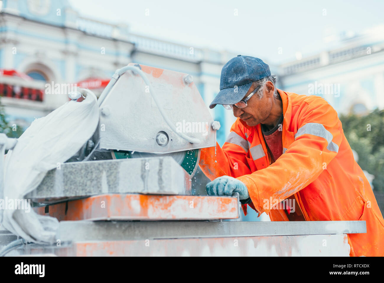 Moskau, Russland - 14. August 2015: ein Builder schneidet ein Stück Granit Stein auf einer Kreissäge. Wiederaufbau der Bürgersteig Fliesen in der Hauptstadt Stockfoto