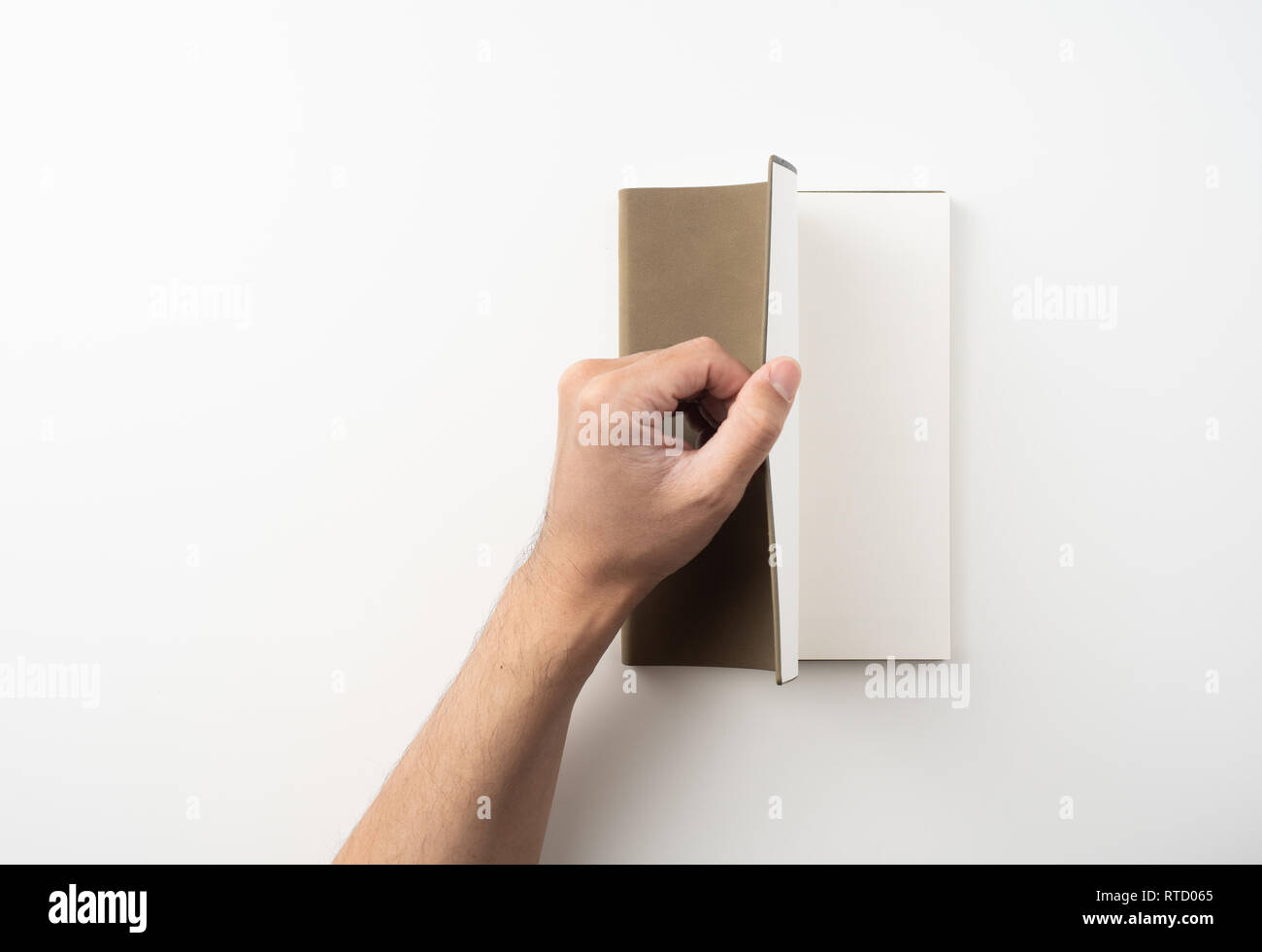 Designkonzept - Blick von oben auf die Hand des Menschen halten Hochwertige braun Notebook auf weißem Hintergrund für mockup Serie 4 isoliert Stockfoto