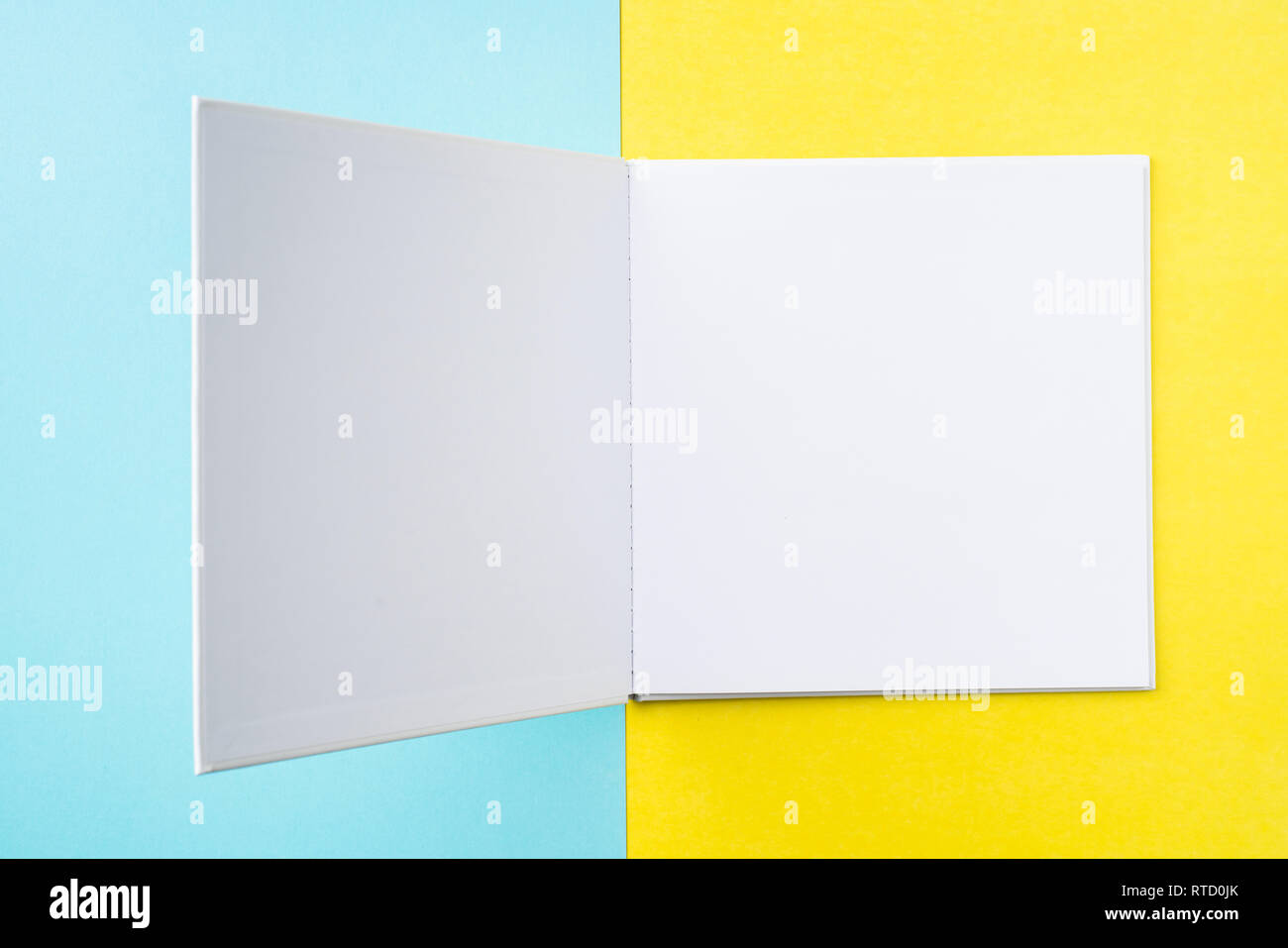 Designkonzept - Ansicht von oben öffnen Quadratische weiße Notebook auf bunten gelber und blauer Hintergrund für mockup Serie 11 Stockfoto