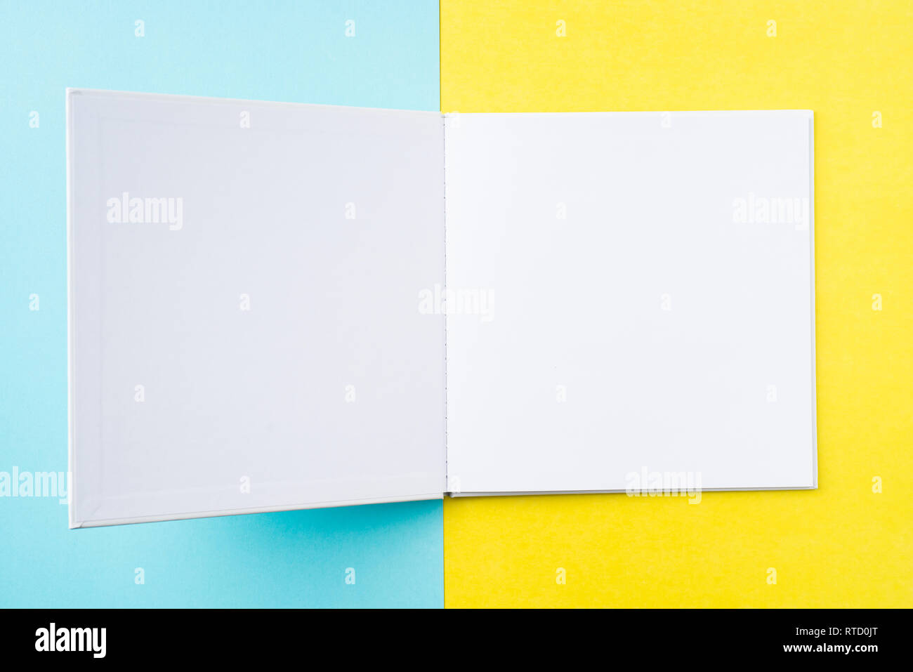 Designkonzept - Ansicht von oben öffnen Quadratische weiße Notebook auf bunten gelber und blauer Hintergrund für mockup Serie 12 Stockfoto