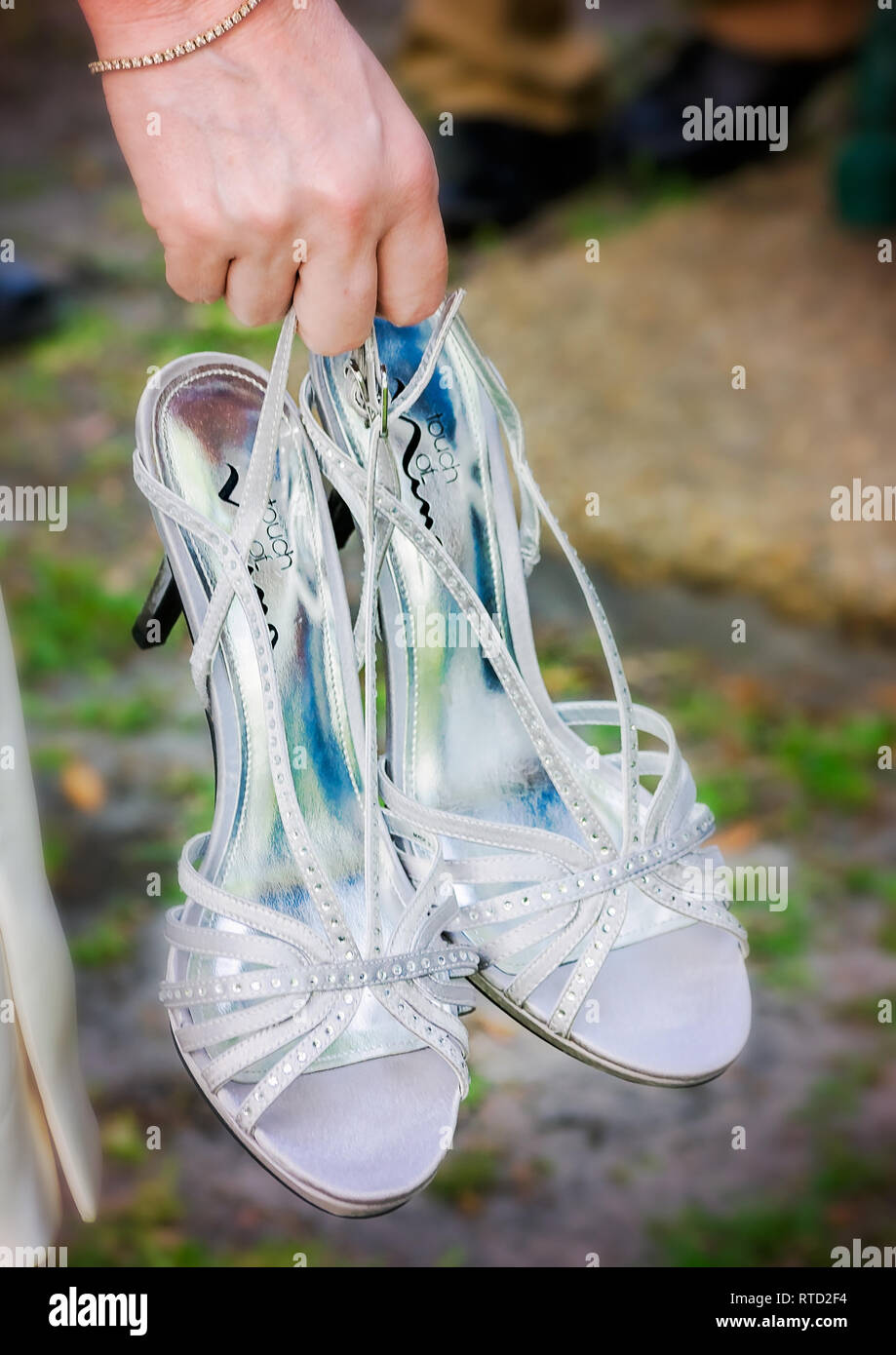 Die Braut trägt Ihr high-heeled Hochzeit Schuhe nach der Hochzeit bei Marshall Park in Ocean Springs, Mississippi. Stockfoto