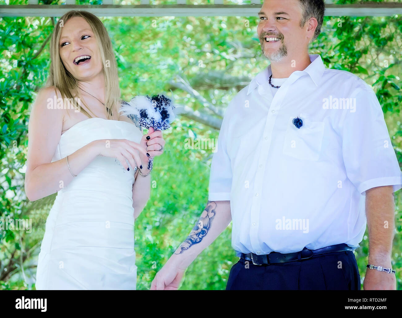 Brautpaar Lachen, während sie nach ihrer Hochzeit Zeremonie am Marschall Park in Ocean Springs, Mississippi sprechen. Stockfoto