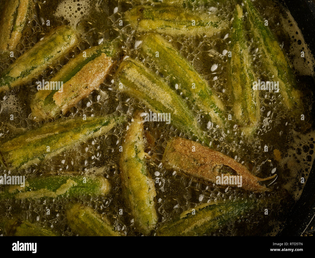 Gewürzt Okra braten in sauberes Öl gegen einen dunklen Hintergrund essen Foto Stockfoto