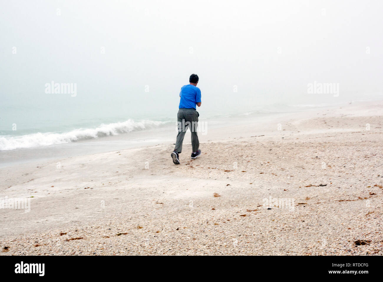 Leute erhalten Übung am Strand an einem nebligen Tag auf Anna Maria Island, Florida, USA. Stockfoto